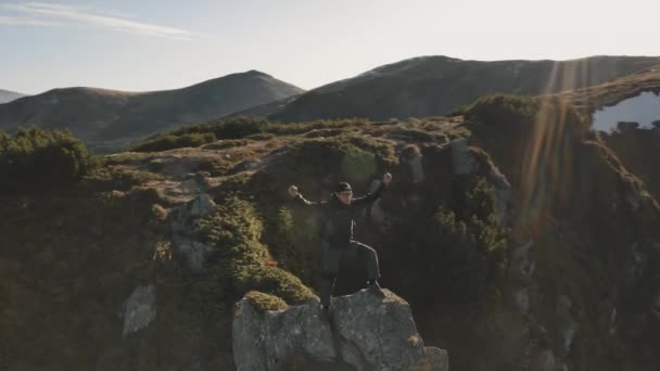 Turista levantándose de la mano en la cima del sol montaña roca aérea. Naturaleza paisaje. Montañismo extremo — Vídeo de stock