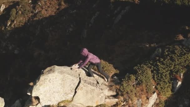 Chica viajera escalar en la roca aérea. La cima de la montaña. Gente en el paisaje natural. Turistas en otoño — Vídeos de Stock