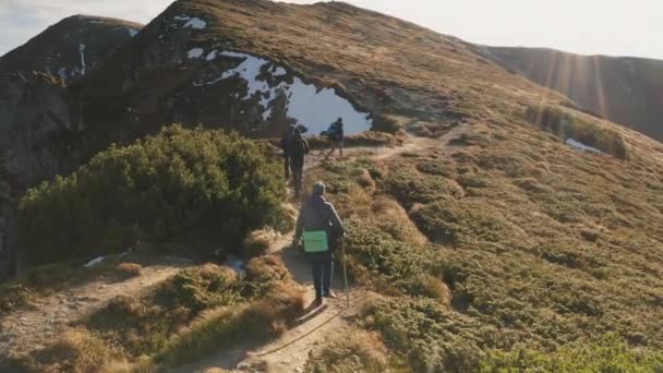 Voyageurs randonnée au sentier de montagne aérienne. Les gens à la nature paysage. Sommet de la montagne avec neige, herbe — Video