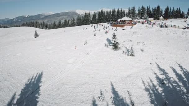 マウンテンリゾート空中の雪のスキー場。人々はスポーツをする。冬の太陽の日の自然景観 — ストック動画