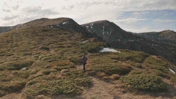 Mujer corriendo en las crestas de las montañas del sol. Chica viajera en el monte colina de senderismo a la cima. Naturaleza paisaje — Vídeos de Stock