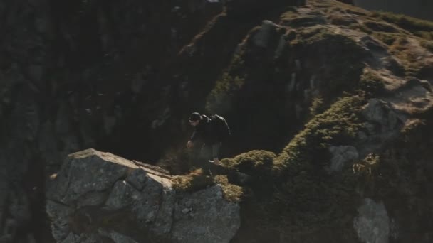 Escalada del viajero en la cima de roca de montaña aérea. Sol paisaje de la naturaleza. El hombre levantándose y agitando las manos — Vídeos de Stock