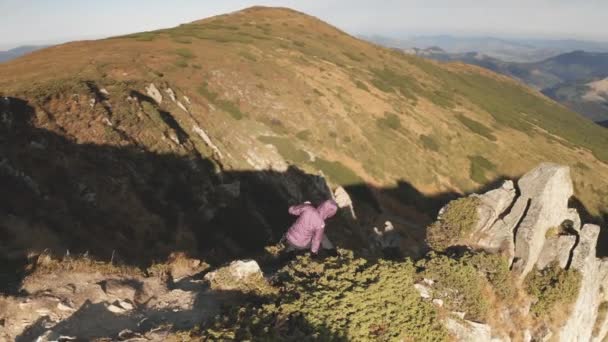 Kapalı hava kızı, uçurumun tepesine tırmanıyor. Turist yürüyüşü. Sonbahar doğa manzarası — Stok video