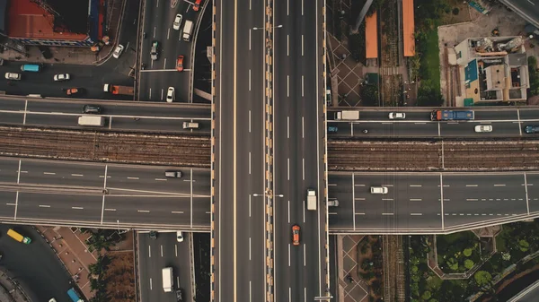 Von oben nach unten überqueren Sie die Autobahn mit Autos, LKWs aus der Luft. Stadtverkehr an der Brückenstraße in der Stadt — Stockfoto