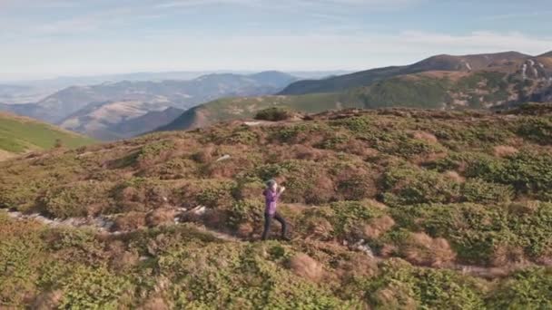 Femme randonnée au soleil montagne aérienne. Touriste fille regardant autour de paysage naturel. Alpinisme — Video