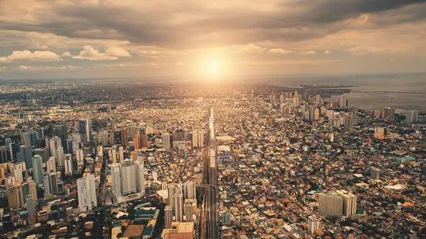 Sun over city roofs of skyscrapers buildings aerial. Urban traffic road at streets of downtown — Stock Photo, Image