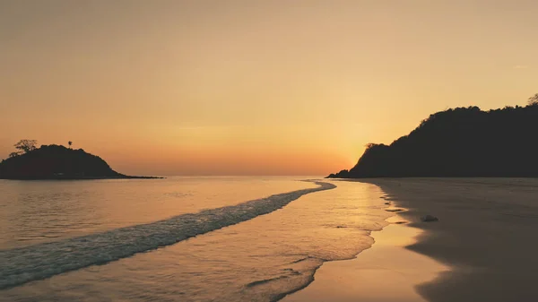 海の湾で島の夕日の山のシルエット。海の砂の海岸の誰も自然の風景 — ストック写真