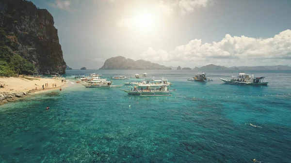 Vzdušný sluneční plášť v zátoce Oceánů azurová voda. Cestovatelé na lodích na mořském pobřeží resort. zelená hora — Stock fotografie
