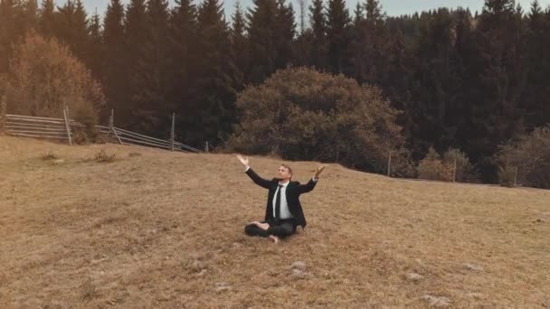 Ділова людина піднімає руки на вершині гори сонця. Відпочинок бізнесменів. Природний ландшафт — стокове відео