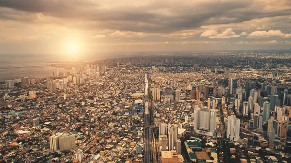 Sun cityscape of port town Manila aerial. Sunrise light over modern buildings and skyscrapers — Stock Photo, Image