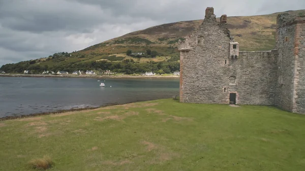 Closeup castle walls ruins at seascape aerial. Historic British palace of Hamilton dynasty on coast — Stock Photo, Image