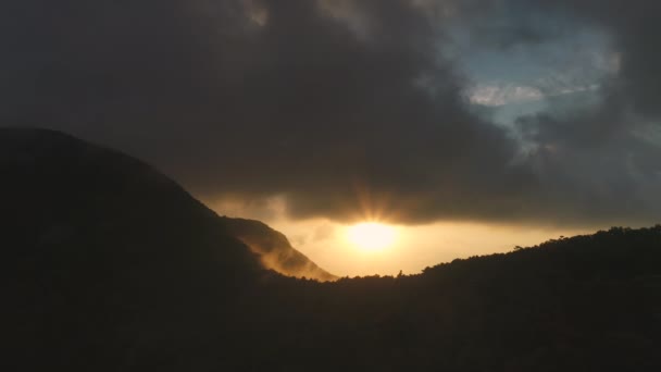 Tajlandia zachód słońca, sylwetka góry zdjęcia lotnicze: dżungla z ciemnym deszczem chmury i promienie słońca — Wideo stockowe