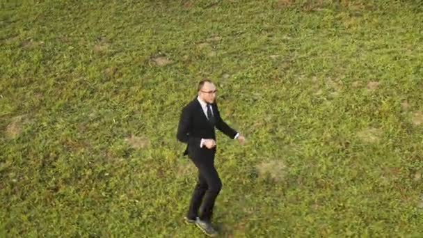 El hombre de negocios baila en la montaña de hierba aérea. Paisaje natural otoñal. Gente vacaciones de recreación — Vídeos de Stock