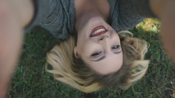 Kobieta plus rozmiar zrobić selfie zbliżenie. Pozytywna blondynka leżała na trawie. Letni krajobraz przyrody — Wideo stockowe