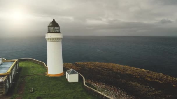 Vit fyr vid solens havsvik närbild antenn. Ingen naturlandskap. Isolerar byggnader på havet — Stockvideo