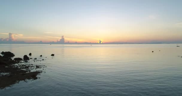 Sunrise Tailândia silhueta aérea: mulher levantar as mãos, permanece na praia rochosa perto de água serena — Vídeo de Stock