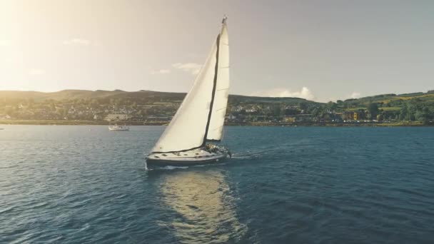 Luxusjacht segelt an der Sonnenbucht aus der Luft. Niemand Natur Seenlandschaft. Segelboot im Hafen der Berginsel — Stockvideo