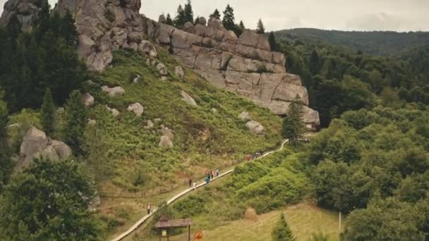 Ludzie wędrują po historycznych murach fortu. Starożytny zamek na zielonym szczycie góry. Atrakcja turystyczna — Wideo stockowe