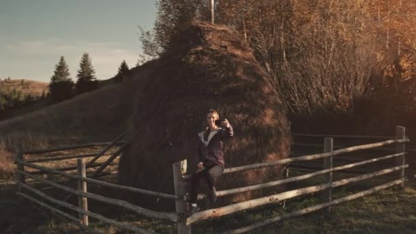 Mujer haciendo selfie en el teléfono en la montaña rural aérea. Otoño sol naturaleza paisaje. Chica en la valla — Vídeos de Stock