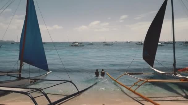 Filipinas, Ilha Boracay, 2018.04.08: Veleiros, navios na costa marítima aérea. As pessoas nadam no oceano — Vídeo de Stock