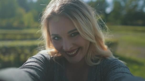 Zbliżenie bokeh portret ciała pozytywnej blondynki. sexy kobieta wziąć aparat w ręce w słońce park — Wideo stockowe