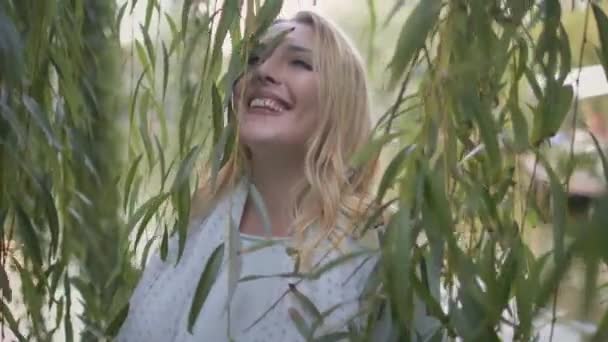 Gros plan heureux corps fille positive jouer avec saule arbre au parc. Paysage naturel ensoleillé. Femme blonde — Video