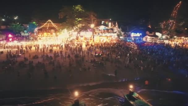 Koh Phanghan, Thailand, 2018.03.02:夜のライトアップされたビーチパーティーの人々。空中パノラマショット — ストック動画