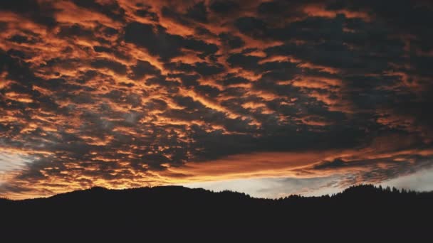 Mörk solnedgång över bergskedjans silhuettantenn. Solen går ner ovanför det vilda naturlandskapet. Dramatisk himmel — Stockvideo