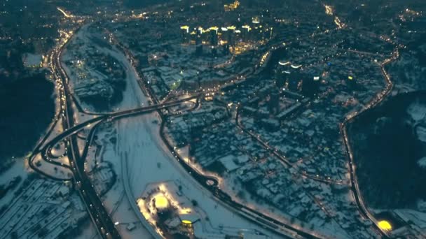 Skrzyżowania dróg w nocy zimowy pejzaż miejski z góry na dół widok z powietrza. Śnieg nad budynkami. Jazda samochodem — Wideo stockowe