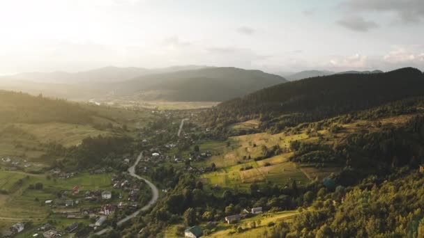 Sun over mountain village aerial. Houses at road with cars. European town. Countryside buildings — Stock Video