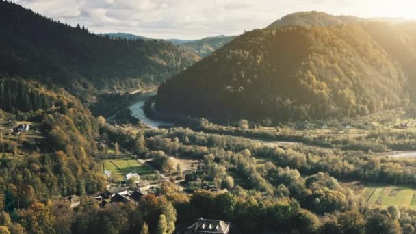 Valle de la montaña del sol con pueblo en la orilla del río aérea. Ciudad aislada junto al campo. Naturaleza paisaje — Vídeos de Stock