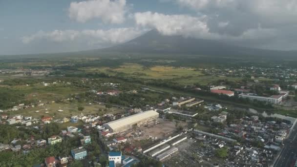 Tropische stad bij vulkaanuitbarsting antenne. Platteland straten op groene vallei van Mayon berg heuvel — Stockvideo