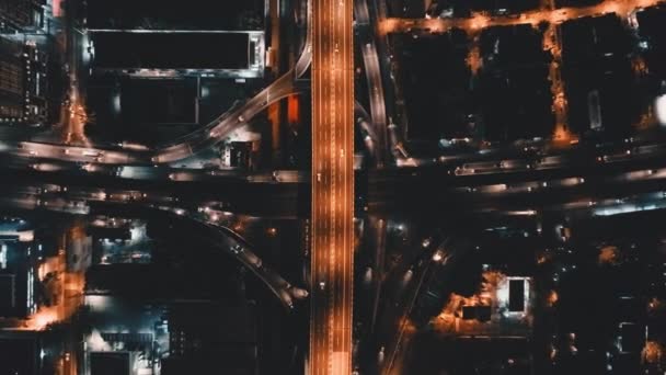 Autopista de tráfico nocturno de arriba hacia abajo en la ciudad aérea. Ilumina el paisaje urbano. Camino urbano, edificios modernos — Vídeos de Stock