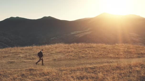 Solnedgang efterår bjerglandskab. Forretningsmand på vandretur på landet. Vild natur – Stock-video