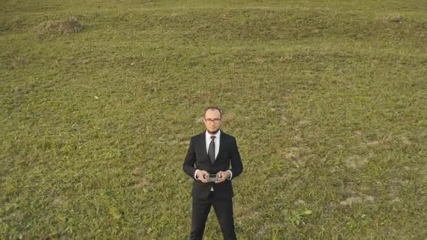 Homme d'affaires professionnel exploiter drone debout en plein air sur prairie d'herbe verte. Loisirs mode de vie de vacances — Video