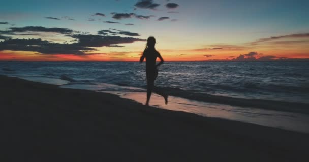 Exercício de mulheres em câmara lenta na praia do pôr-do-sol. Mulher correndo ao ar livre, pessoas ativas, estilo de vida saudável — Vídeo de Stock