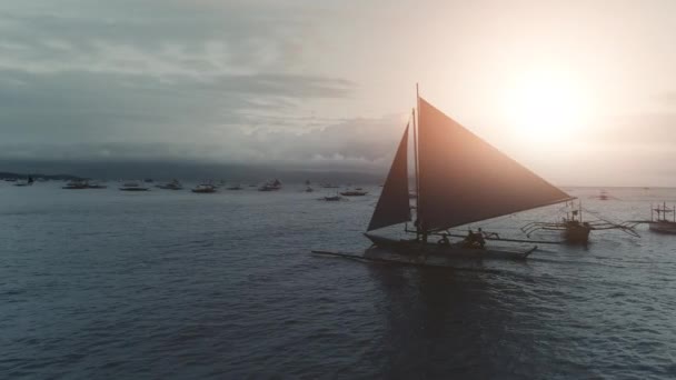 Silhueta de barco de pesca navegar no pôr-do-sol oceano. Ilha tropical no fundo — Vídeo de Stock