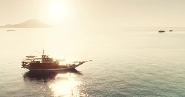 Letecké panorama: dvě jachty plachtění v blízkosti tropického ostrova. Slunce zapadá v klidné mořské vodě — Stock video