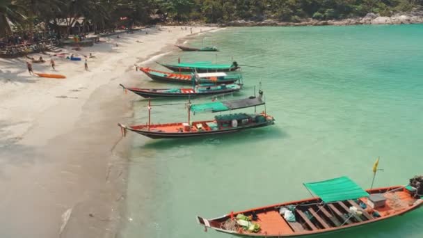 Barcos aéreos tradicionales están aparcados cerca de la playa de arena. Turistas tomar el sol durante en la orilla, frontera abierta — Vídeos de Stock