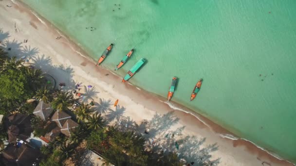 空中俯瞰着沙滩海岸附近的屋顶和国家船只。绿松石海夏季热带岛屿 — 图库视频影像