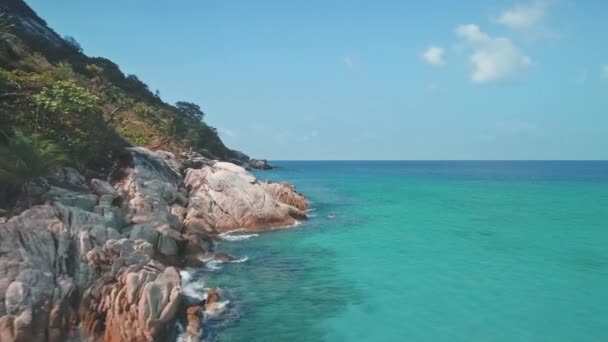 Aereo mare blu batte contro rocce con palme e alberi. Lento volo sopra bella eco deserto. — Video Stock