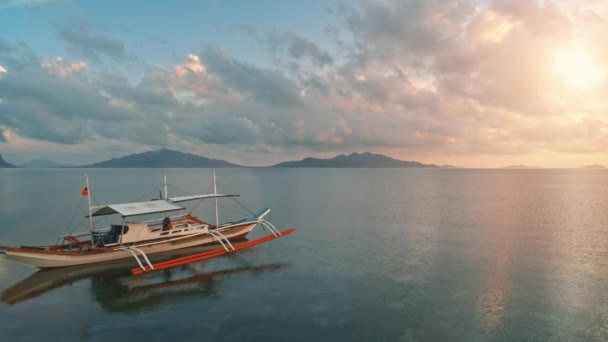 Philippines wooden boat in colorful paradise sunset. Drone low fly over traditional Bangka ship — Stock Video