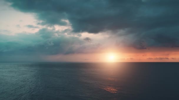 Драматический красочный океанский закат. Воздушный замедленный полет. Ярко-оранжевое отражение солнца в морских волнах — стоковое видео