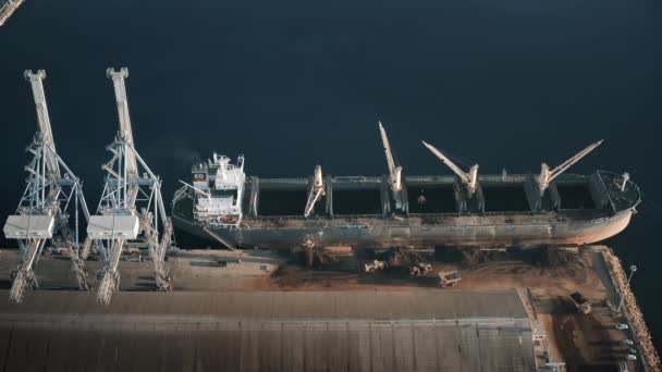 Grúas cargan buque de carga seca en puerto. Vista aérea del envío muchos camiones transportan arena desde un barco grande — Vídeo de stock