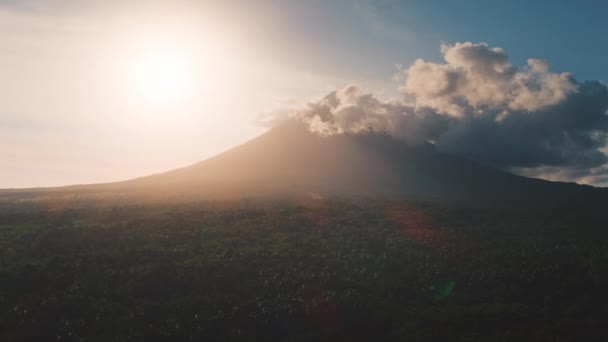 Vista aérea pie volcán activo y árboles verdes. Cono vieja montaña en brillante cielo nublado fondo. — Vídeo de stock