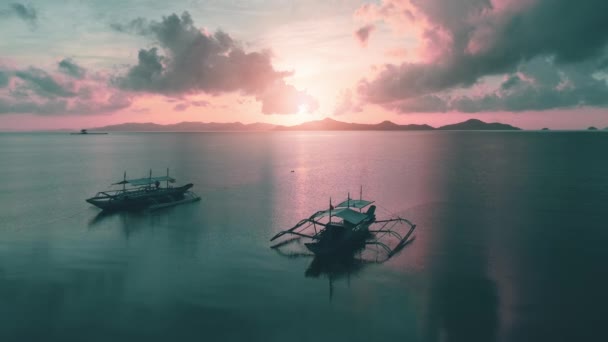 Vista aérea, pôr do sol lilás sobre o mar azul. Barcos nacionais filipinos no mar. Viagem bela paisagem. — Vídeo de Stock