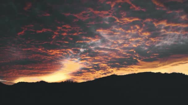 Drámai ég, fekete és vörös naplemente a hegyek felett, légi kilátás. Mennydörgő felhők az erdő felett a hegyekben. — Stock videók