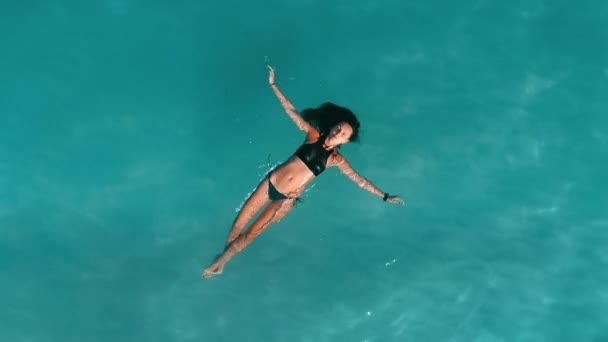 Mulher bronzeada aérea a flutuar de costas no mar azul. Linda menina esbelta brilhante sandbank — Vídeo de Stock