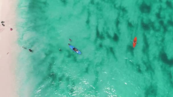 Hombre en kayak en agua azul, playa de arena, vista aérea. Textura de agua transparente cerca de la zona costera. — Vídeos de Stock