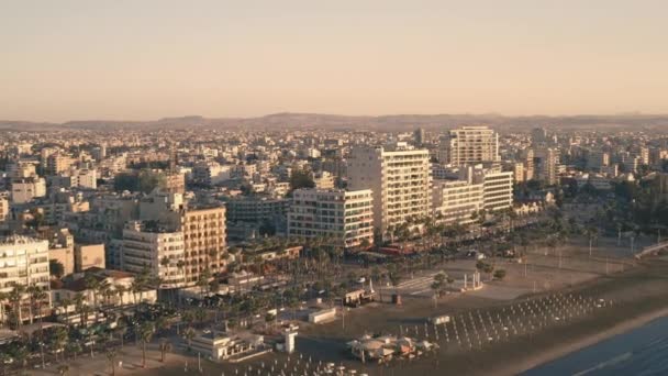 Vista aérea de la playa y la costa de la ciudad moderna en el mar. Casas y palmeras en Larnaca, Chipre — Vídeo de stock